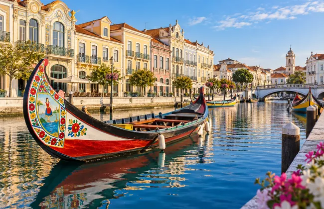 Ilustração de um moliceiro pintado num canal do centro de Aveiro, com fachadas coloridas ao fundo